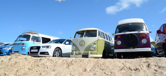 campervans and cars parked on a beach