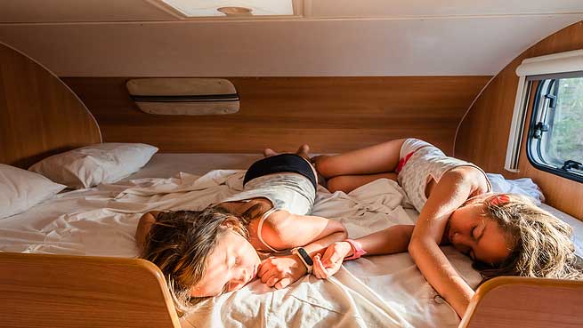 two children sleeping in a motorhome